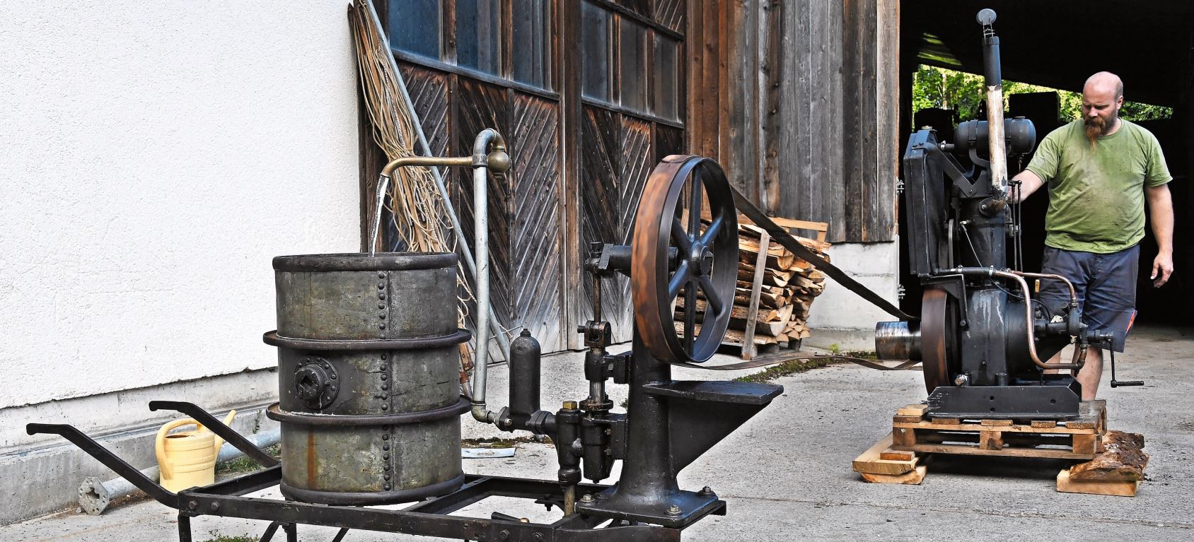 Christian Maag bringt eine Wasserpumpe mit einem Benzinmotorantrieb, der aus dem Jahre 1920 stammt, zum Laufen.