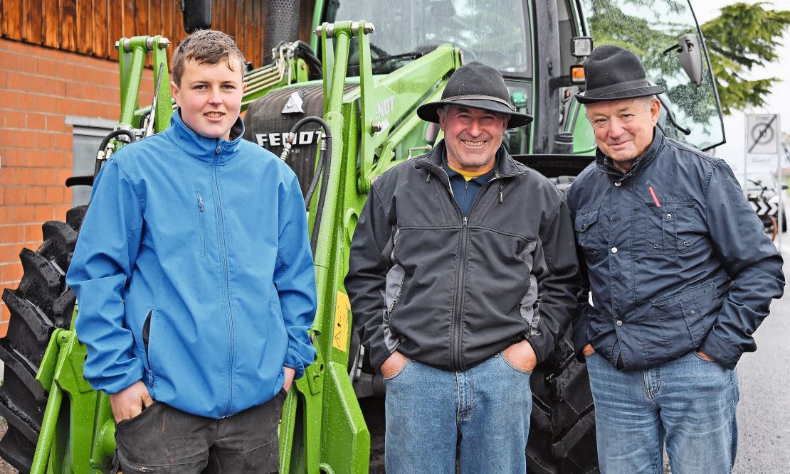 Markus Ebneter (Bildmitte) und sein Sohn Alex freuen sich über ihren Fendt-Traktor – neben ihnen steht Gantrufer Bruno Furrer.